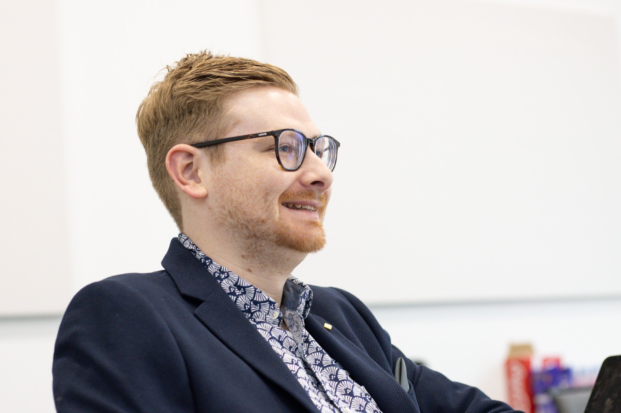 Tom Wardman smiling as he listens to a client during a conversation about where to start.