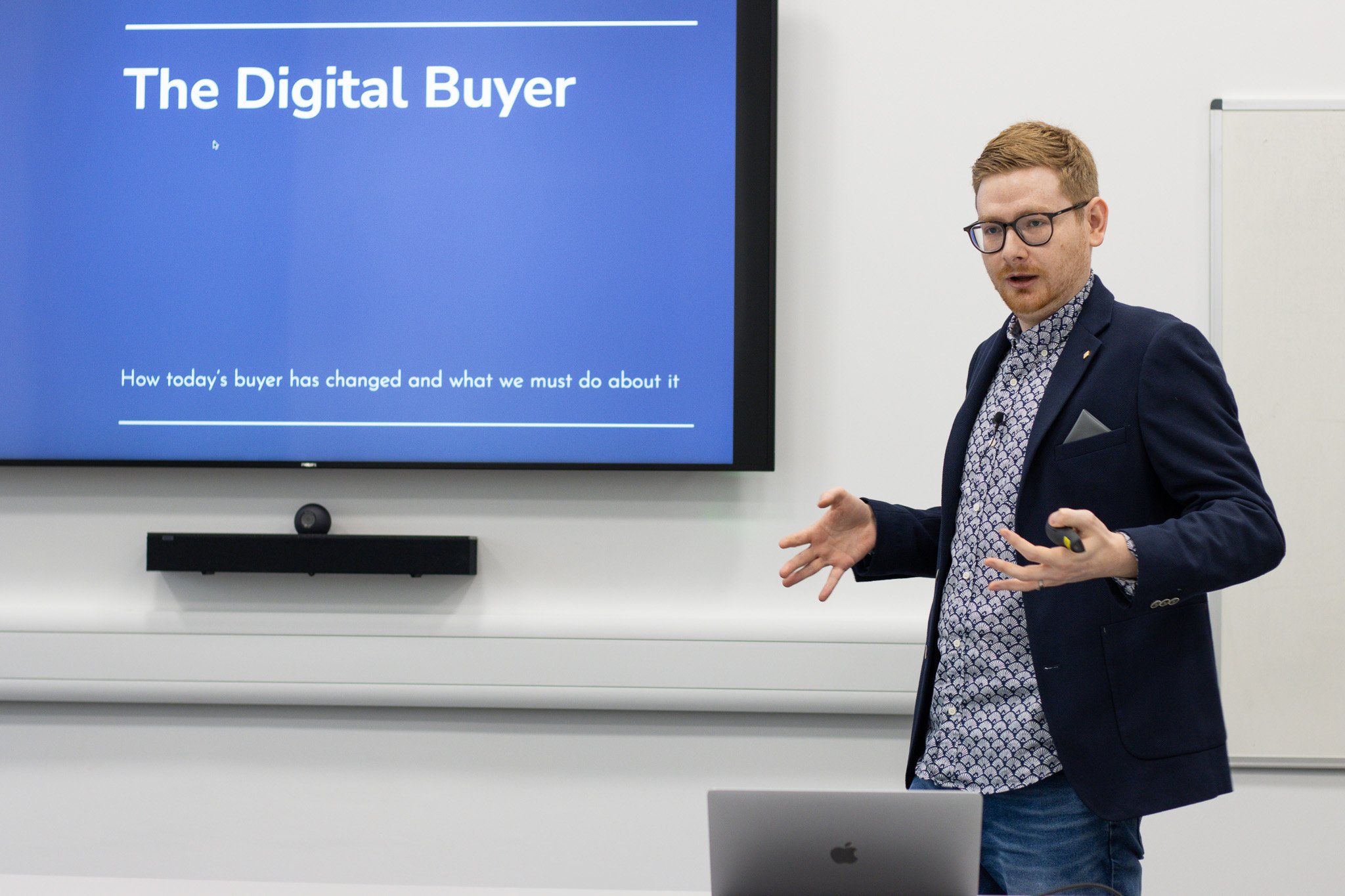 Tom Wardman presenting a talk on how today’s buyer has changed, gesturing to the audience