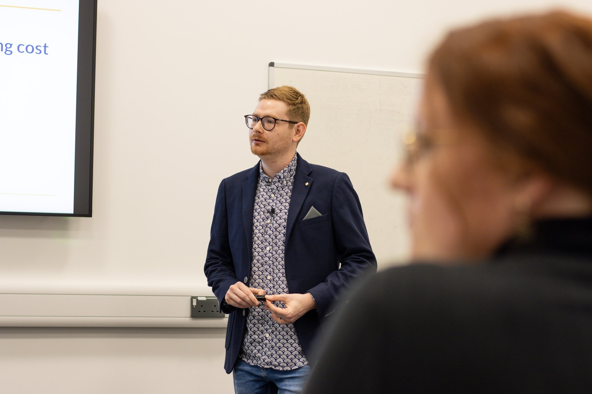 Tom Wardman presenting to a leadership team, with an attendee listening in the foreground