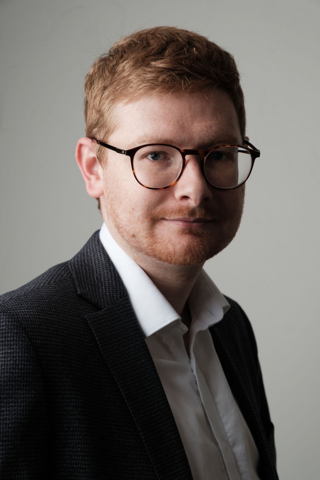 Tom Wardman in a dark blazer, smiling at the camera